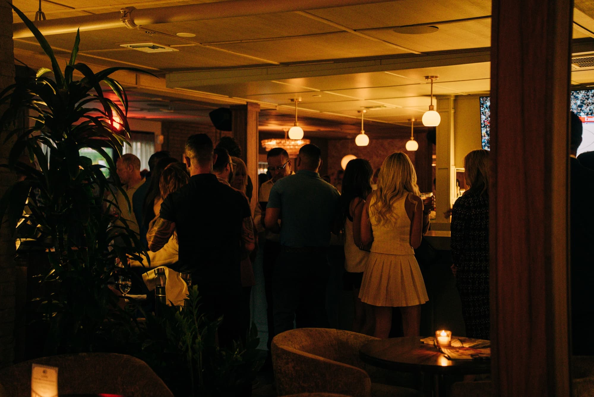 Guests gathered in the warm-lit bar and lounge at 40 Love during an evening event